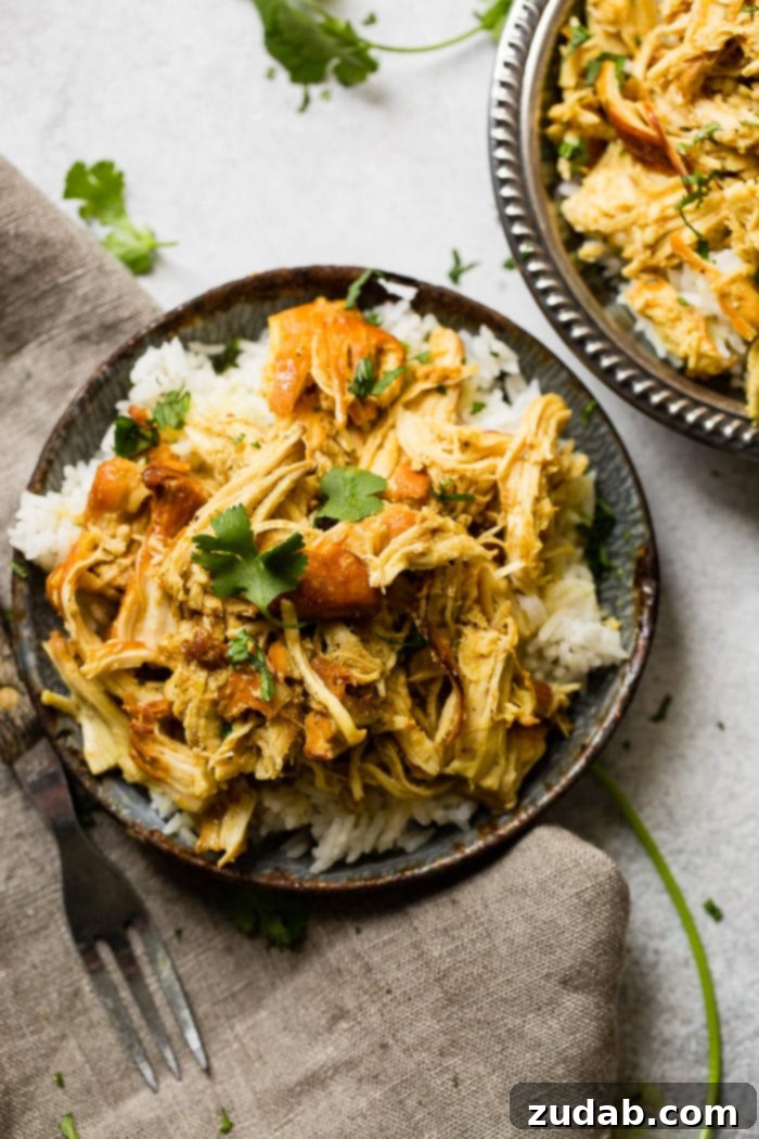 Instant Pot Sticky Honey Chicken 3 A metal, vintage bowl filled with white long grain rice and shredded chicken with a simple honey curry sauce made in an instant pot with cilantro on top. easy instant pot honey chicken