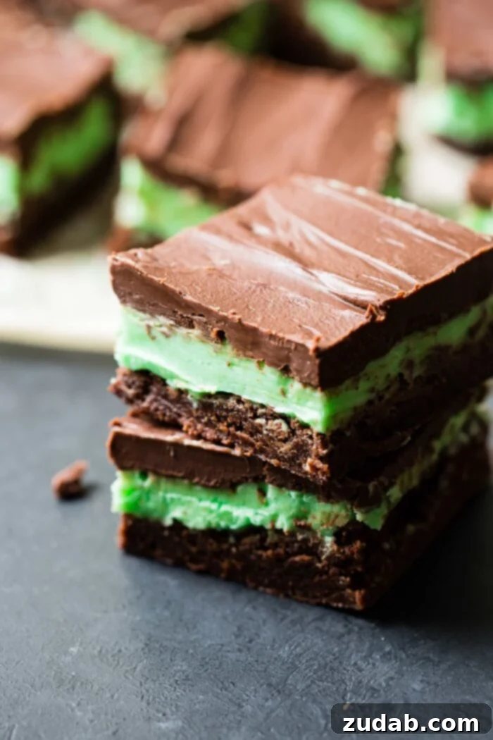 BYU Mint Brownies: The Homemade Version 2 A black board with rich chocolate brownies, a vibrant mint frosting, and a glossy chocolate ganache layered on top. Our homemade copycat BYU mint brownies from scratch are a stunning dessert.