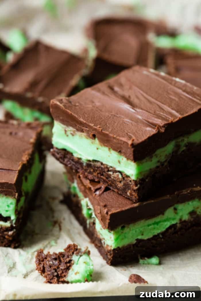 BYU Mint Brownies: The Homemade Version 5 A black board with brownies featuring a green mint frosting and a shiny chocolate ganache on top. Our copycat BYU mint brownies from scratch are beautifully plated.