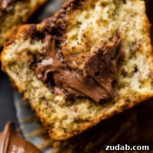 Nutella-Marbled Banana Muffins 7 A soft banana muffin cut in half with a dollop of nutella spilling out of the center