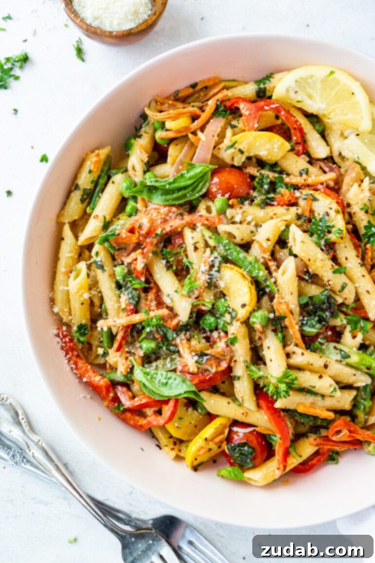 A large bowl of vibrant penne pasta primavera, brimming with fresh vegetables and a creamy sauce, ready to be served.