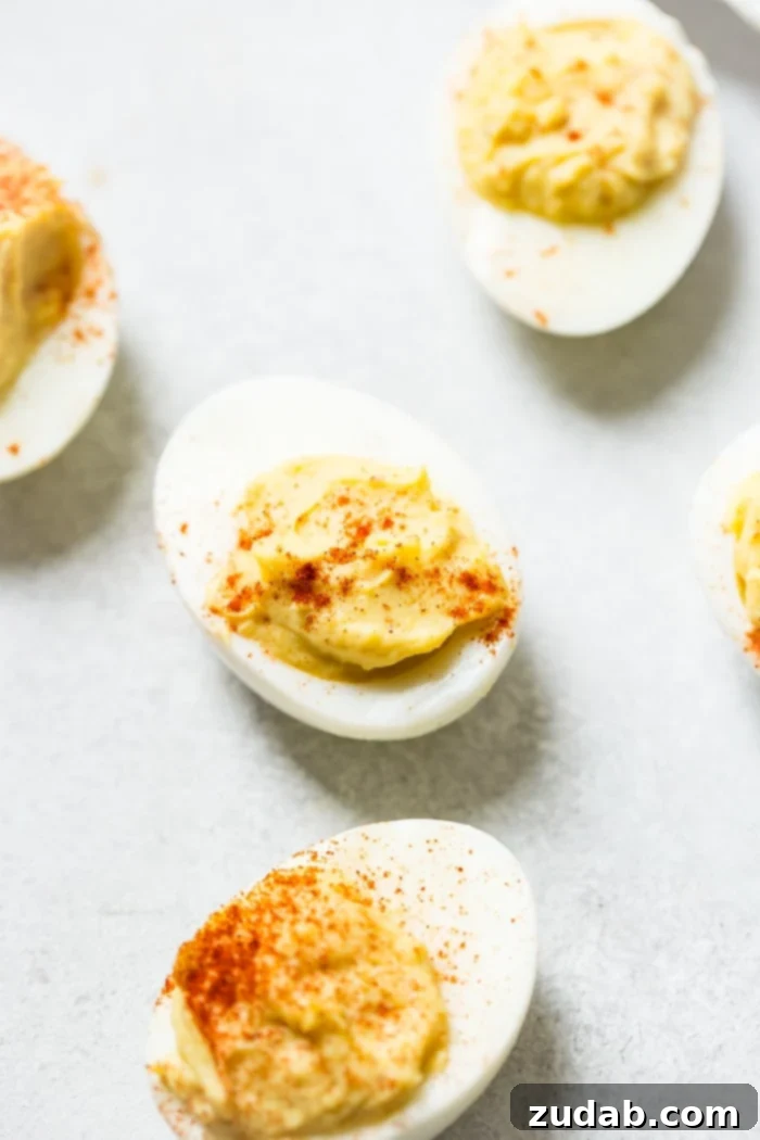 Perfect Deviled Eggs 4 A grey board with deviled eggs with paprika sprinkled on the top which makes the best deviled eggs ever!