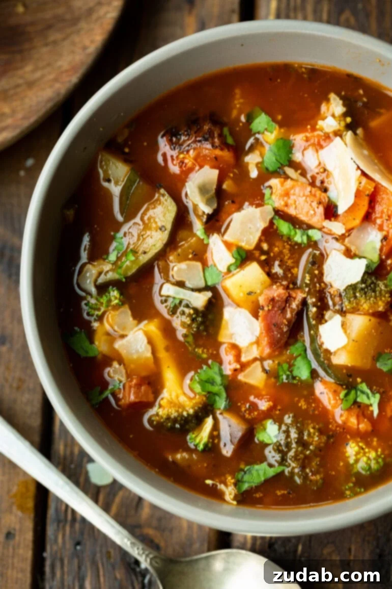 Weight Watchers Ham and Vegetable Soup Tutorial 2 a photo of a bowl of hearty ham and vegetable soup loaded with potatoes, carrots, tomatoes, mushrooms and topped with chopped parsley