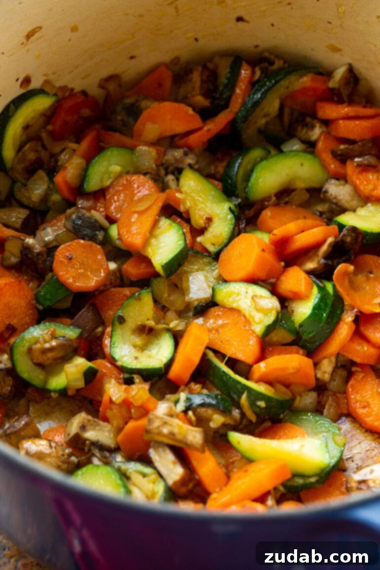Weight Watchers Ham and Vegetable Soup Tutorial 4 a photo of a zucchini, carrots, onions and mushrooms being sauteed in a dutch oven