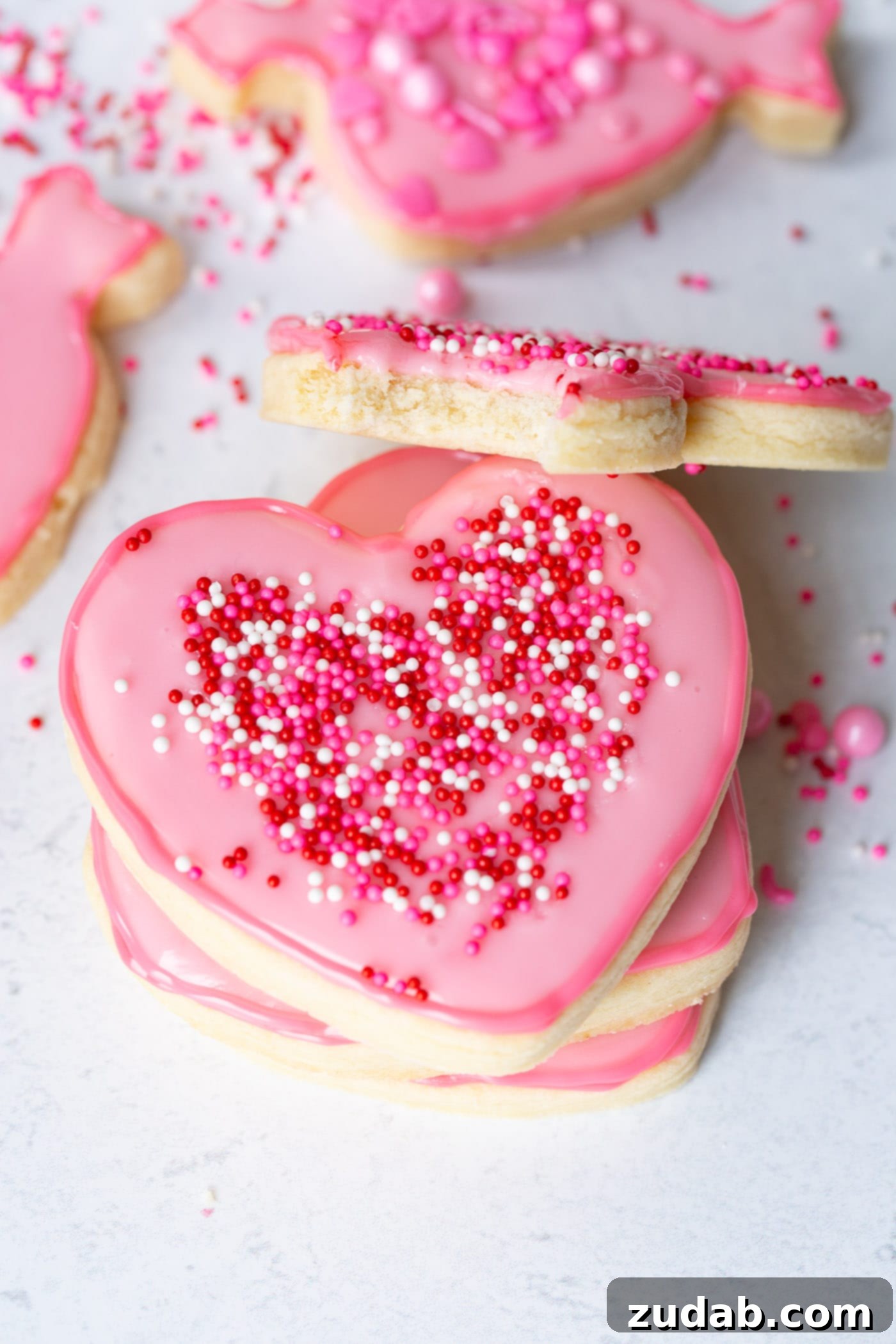 a pink heart sugar cookie with sprinkles
