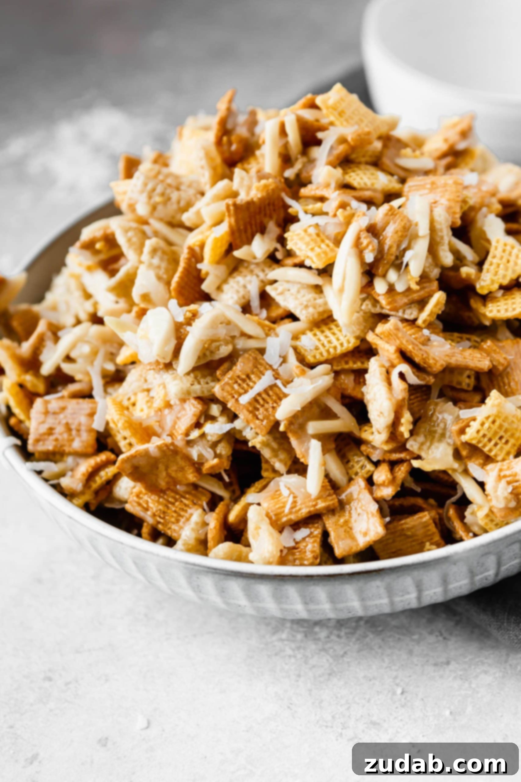 Coconut Sweet Chex Mix A large bowl containing coconut sweet chex mix. It is made of rice chex, corn chex and golden grahams. Slivered almonds and shredded coconut are mixed in with a sweet gooey syrup.