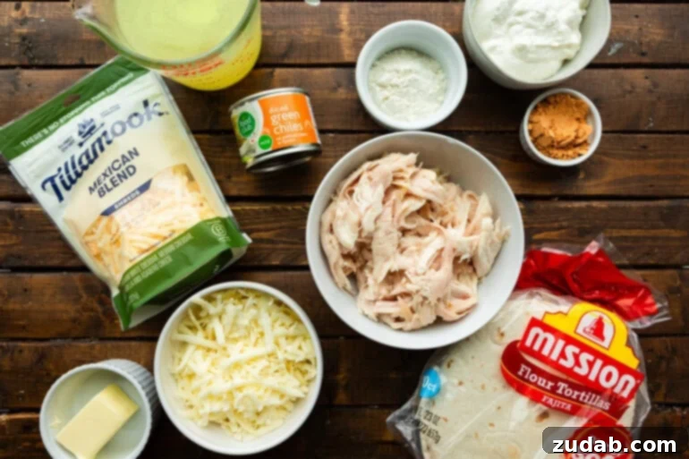 Simple and Delicious Cheesy Chicken Enchiladas 4 a photo of all the ingredients for cheesy chicken enchiladas in separate bowls including flour tortillas, shredded chicken, cheese, canned green chiles, seasonings, etc.