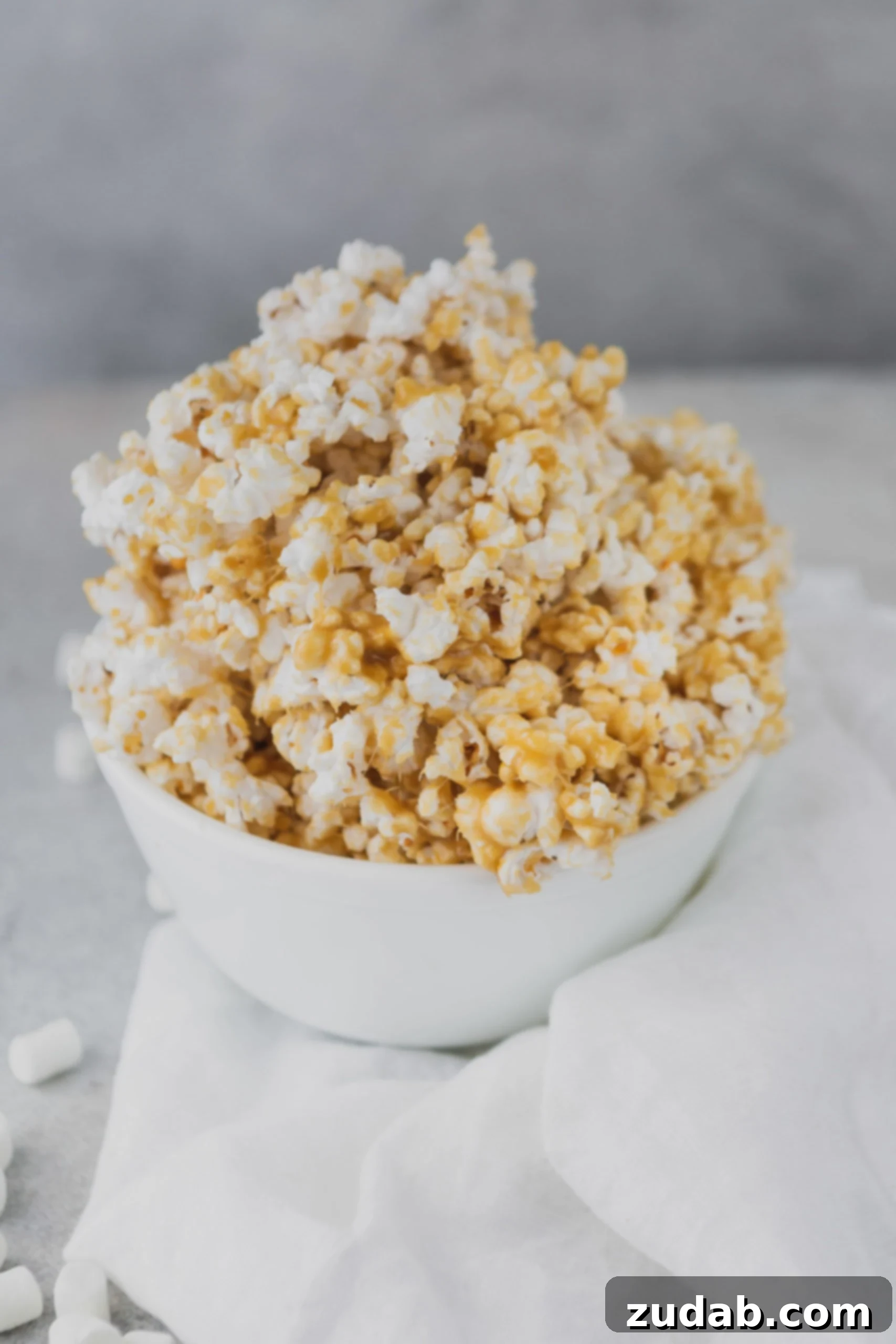 Caramel Popcorn A white bowl brimming with fresh, crispy homemade caramel popcorn, ready to be enjoyed.