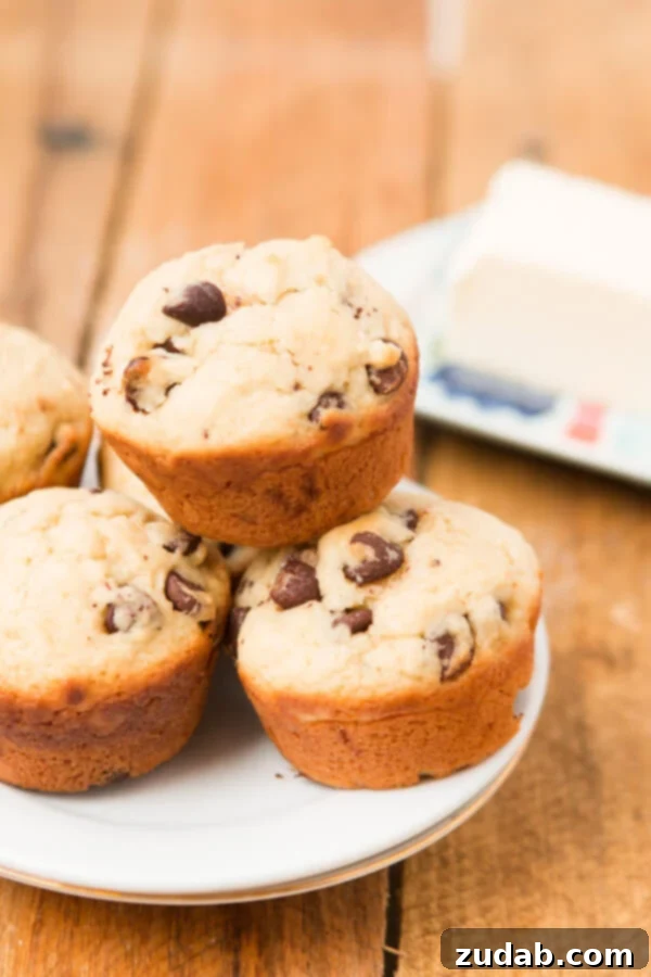 Bakery-Style Chocolate Chip Muffins 14 Close-up of baked chocolate chip cookie muffins, showcasing their golden crust and visible chocolate chips.