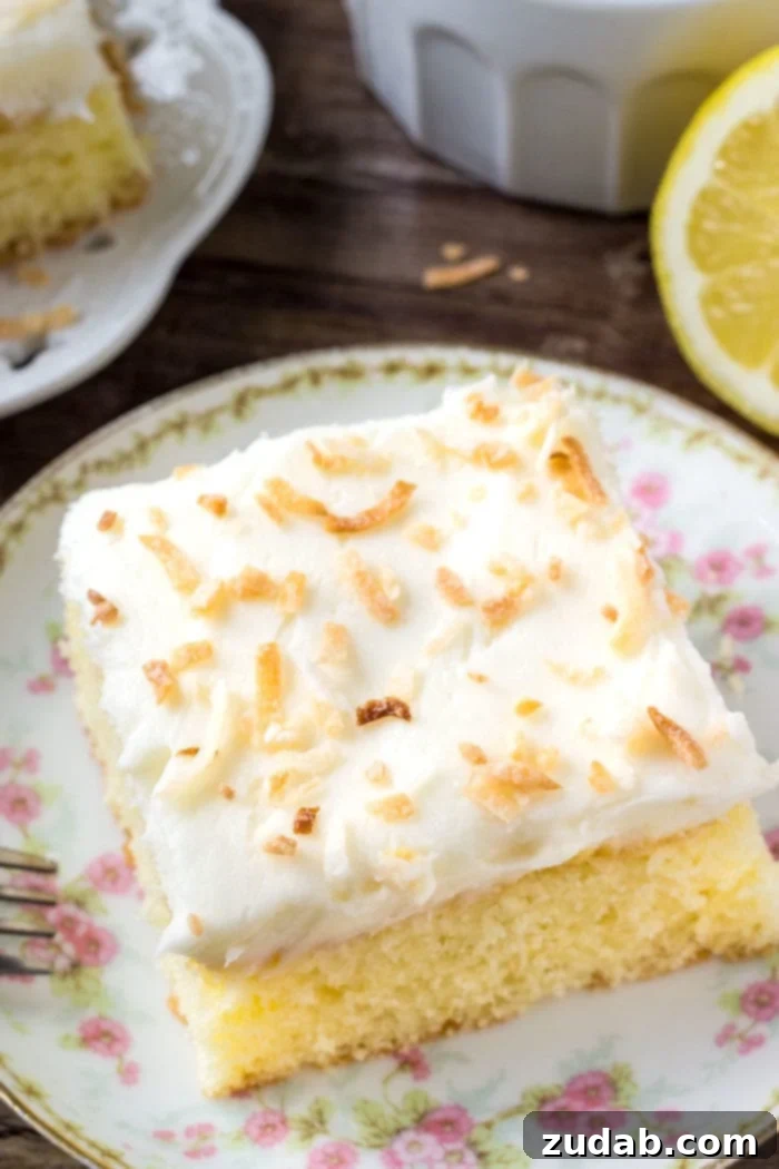 Cloud Nine Lemon Coconut Cake 2 A slice of lemon cake with fluffy coconut frosting topped with toasted coconut.
