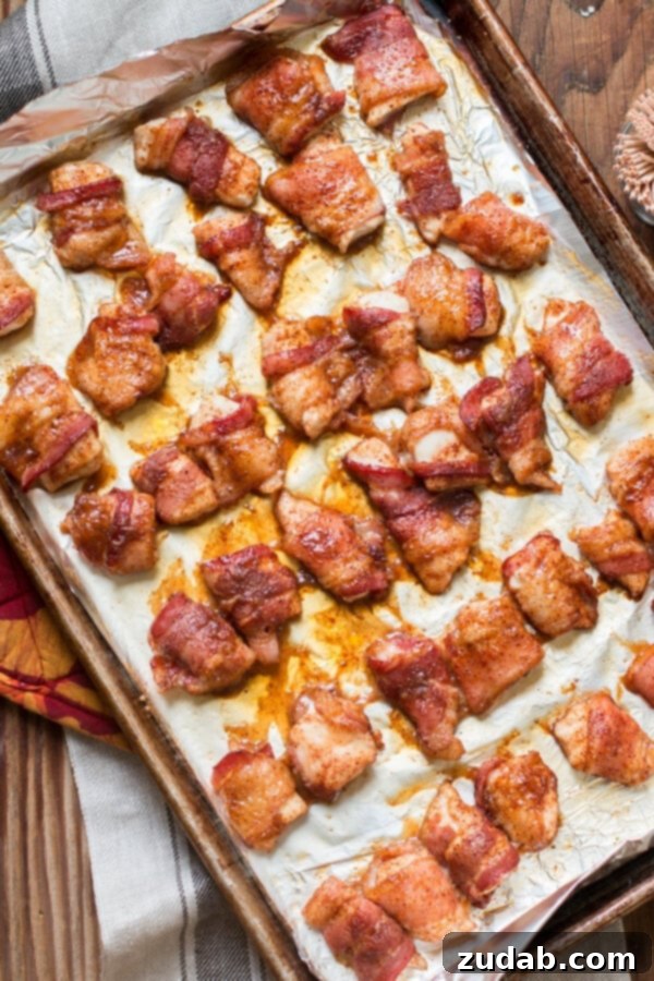 Bacon Wrapped Chicken: A crowd-pleasing appetizer or main dish with sweet and savory flavors. Overhead view of perfectly baked bacon-wrapped chicken on a baking tray, ready to serve