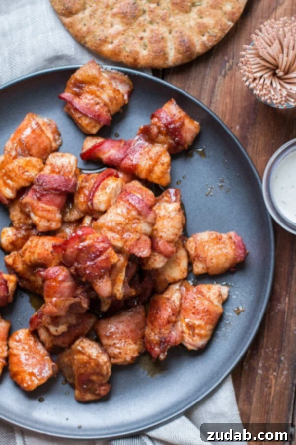 Delicious brown sugar bacon chicken bites, ideal for parties and family meals. Overhead view of a generous pile of brown sugar bacon chicken pieces served on a gray plate.