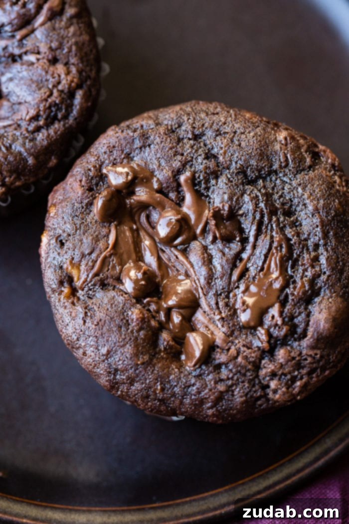 Molten Nutella Double Chocolate Banana Muffins 3 A close-up shot of a single Nutella-stuffed chocolate banana muffin with a delightful texture.
