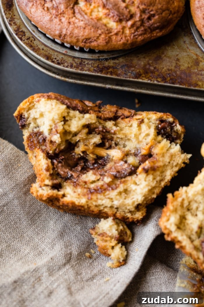 Peanut Butter Banana Muffins with a Gooey Nutella Center 7 A spread of delicious peanut butter banana muffins, generously adorned with chocolate chips, peanut butter chips, and a captivating Nutella swirl.