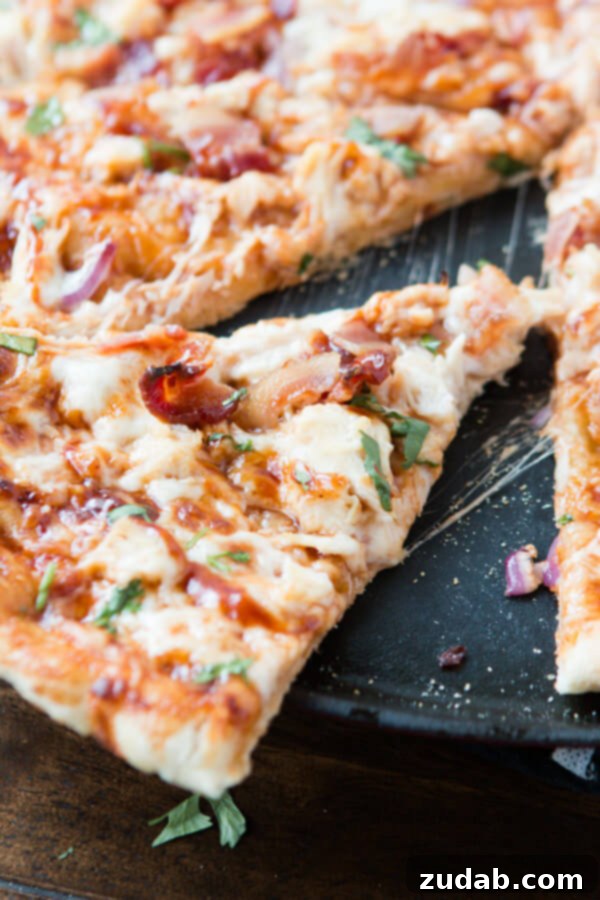 Savoring the Flavor: Our Homemade CPK BBQ Chicken Bacon Pizza A close-up of a freshly baked Copycat California Pizza Kitchen BBQ Chicken Bacon Pizza, showcasing the melted cheeses, succulent chicken, and crispy bacon.