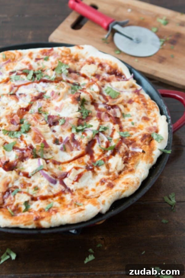 A Slice of Heaven: Our Homemade CPK BBQ Chicken Bacon Pizza Overhead view of a hot slice of Copycat California Pizza Kitchen BBQ Chicken Bacon Pizza, highlighting the blackened chicken, red onions, bacon, and melted cheeses.