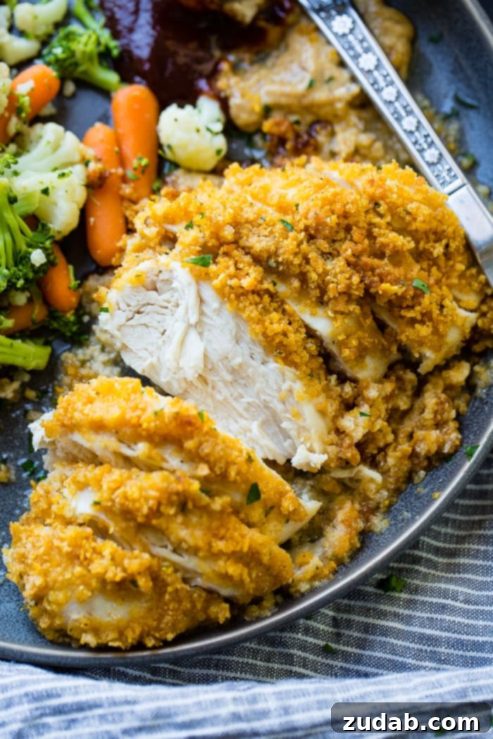 Crispy Ranch Cornflake Chicken 3 A plate of golden-baked Cornflake Ranch Chicken, sliced, accompanied by fresh steamed green beans, ready to be served.