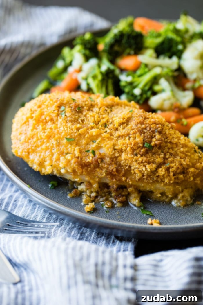Crispy Ranch Cornflake Chicken 5 A serving of golden, sliced Cornflake Ranch Chicken with steamed green beans and yellow squash on a grey plate.