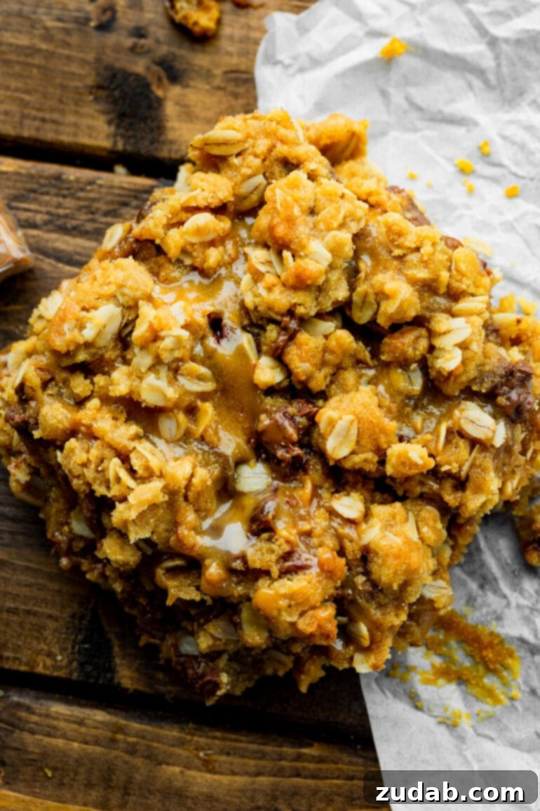 A close-up photo of Carmelitas bars, highlighting their simple yet irresistible layers of oat crumble, gooey caramel, and melted chocolate. This image emphasizes the ease of making these delicious dessert bars.