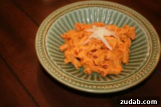 Fire-Roasted Red Pepper Pasta 3 Close-up shot of roasted red pepper pasta, showing the rich, red sauce coating the pasta.