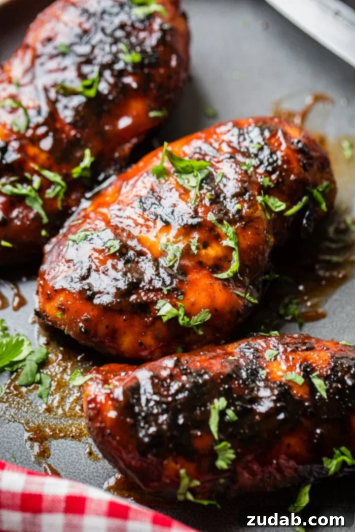 Smoky Grilled BBQ Chicken Bliss 3 A grey plate with multiple grilled bbq sauce chicken breasts sprinkled with cilantro that has been chopped