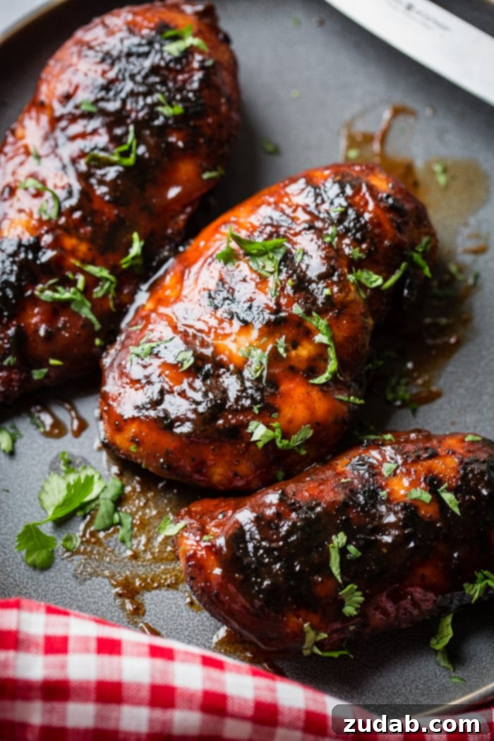 Smoky Grilled BBQ Chicken Bliss 4 A grey plate with multiple grilled bbq sauce chicken breasts sprinkled with cilantro that has been chopped