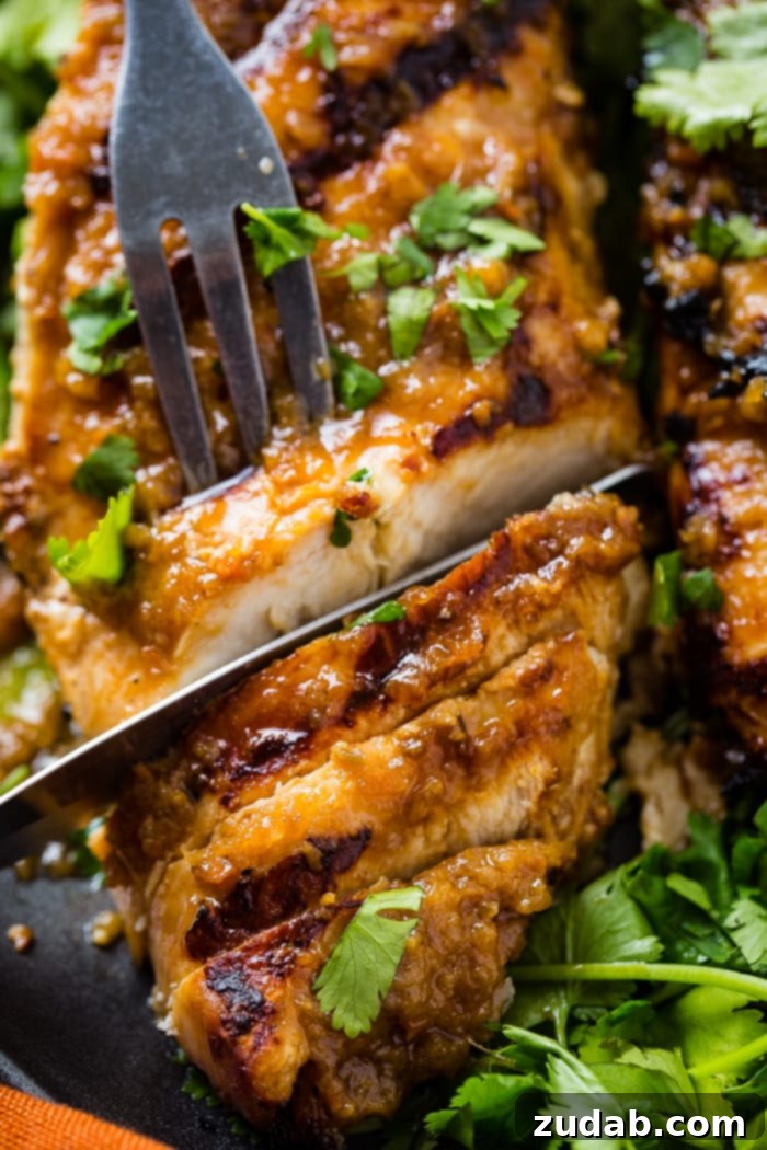 Aromatic Asian Ginger Marinade for Perfect Grilled Chicken 2 A close up of Asian Ginger Marinade for grilled chicken being sliced with a fork and a knife