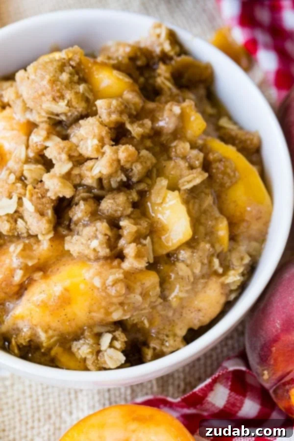 Peach Crisp A photo of a bowl of peach crisp with golden oatmeal topping.