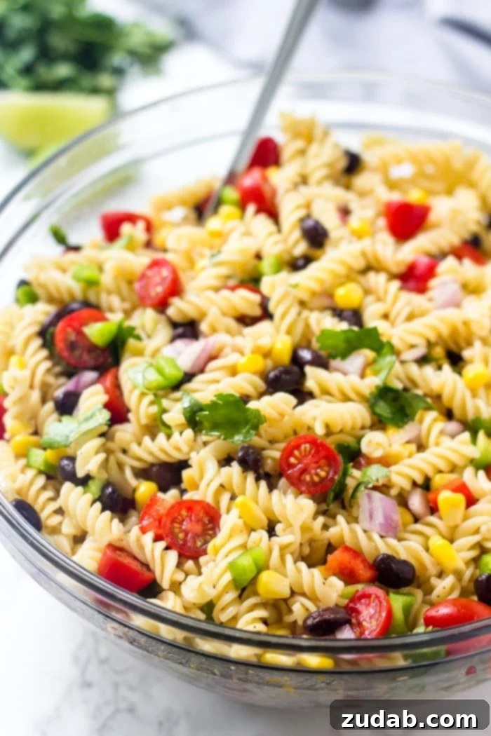 Fiesta Southwest Pasta Salad 2 A vibrant bowl of Southwest Pasta Salad, rich with corn, black beans, chopped tomatoes, bell peppers, and fresh cilantro, ready for serving.