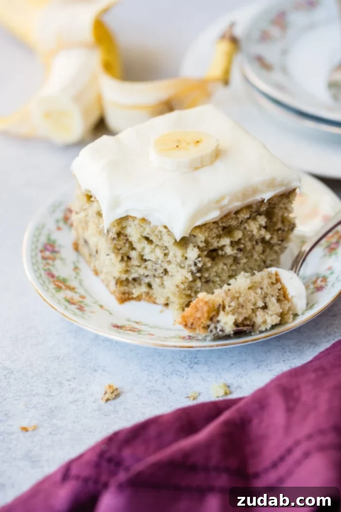 Perfectly Moist Banana Cake 5 A beautifully frosted slice of moist banana cake with cream cheese frosting, ready to be enjoyed.