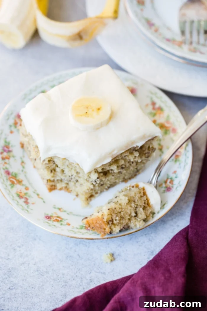 Perfectly Moist Banana Cake 6 The final irresistible image of a slice of banana cake with cream cheese frosting, inviting you to take a bite.