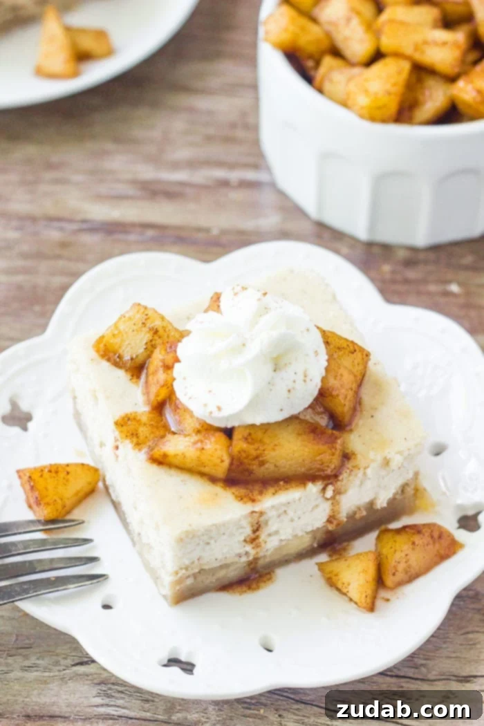 Autumn Apple Cheesecake Squares 3 A slice of apple cheesecake bars topped with cinnamon sugar apples and whipped cream