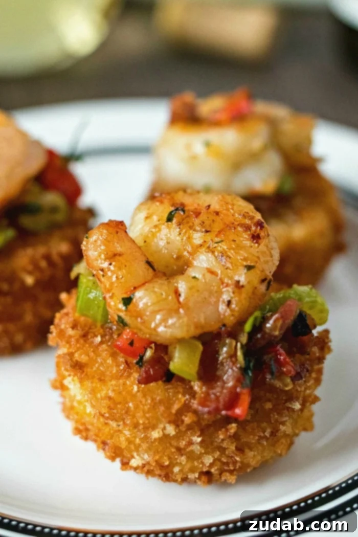 Down Home Cheesy Grits 9 A platter of Shrimp & Grit Cake Bites, featuring small, fried grit patties topped with shrimp and bacon, ideal for an appetizer.