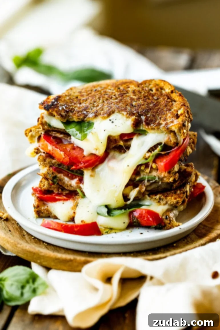 Gourmet Havarti Tomato Basil Grilled Cheese 4 A delectable photo of a stack of melty Havarti tomato basil grilled cheese sandwiches, showing the generous layers of cheese, tomato, and basil, and the inviting golden crust.