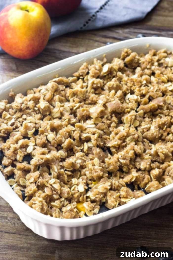 Blueberry Peach Delight 4 Unbaked Blueberry Peach Crisp, showing a generous layer of brown sugar oatmeal topping ready to be baked to golden perfection.