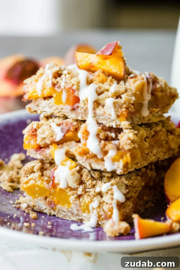 A dark purple plate with a stack of healthy peach oatmeal bars with a little glaze on top, highlighting the delicious texture