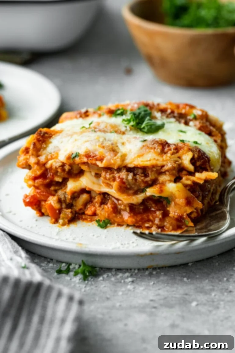 My Go-To Lasagna Masterpiece 12 A beautifully baked meaty lasagna, presented in its baking dish with a clean cut made into the corner, showcasing its delicious, comforting layers ready to be served.