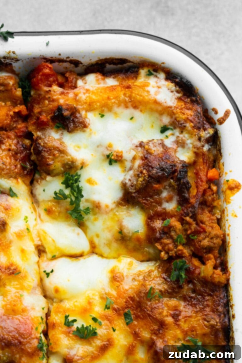 My Go-To Lasagna Masterpiece 9 A baked dish of homemade meat lasagna with a neatly cut-out corner serving, revealing the luscious layers of pasta, rich sauce, and melted cheese, ready for a comforting meal.