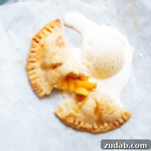 a grey platter with a cup open peach hand pie and a scoop of vanilla ice cream