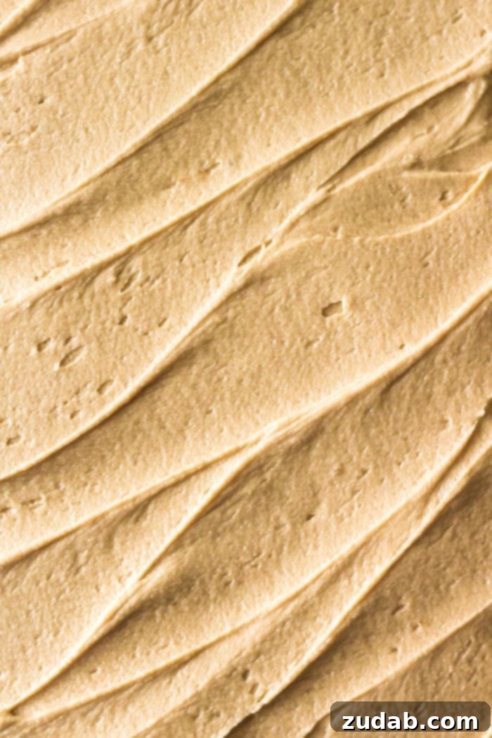 Decadent Caramel Apple Cake 4 Overhead shot of fluffy caramel frosting on an apple spice cake