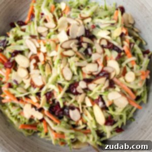 A photo of someone scooping up a serving of broccoli slaw