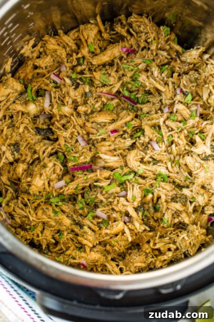 Creamy Instant Pot Poblano Chicken 2 An Instant Pot filled with perfectly shredded Mexican Poblano Instant Pot Chicken, garnished with fresh cilantro, ready to be served.