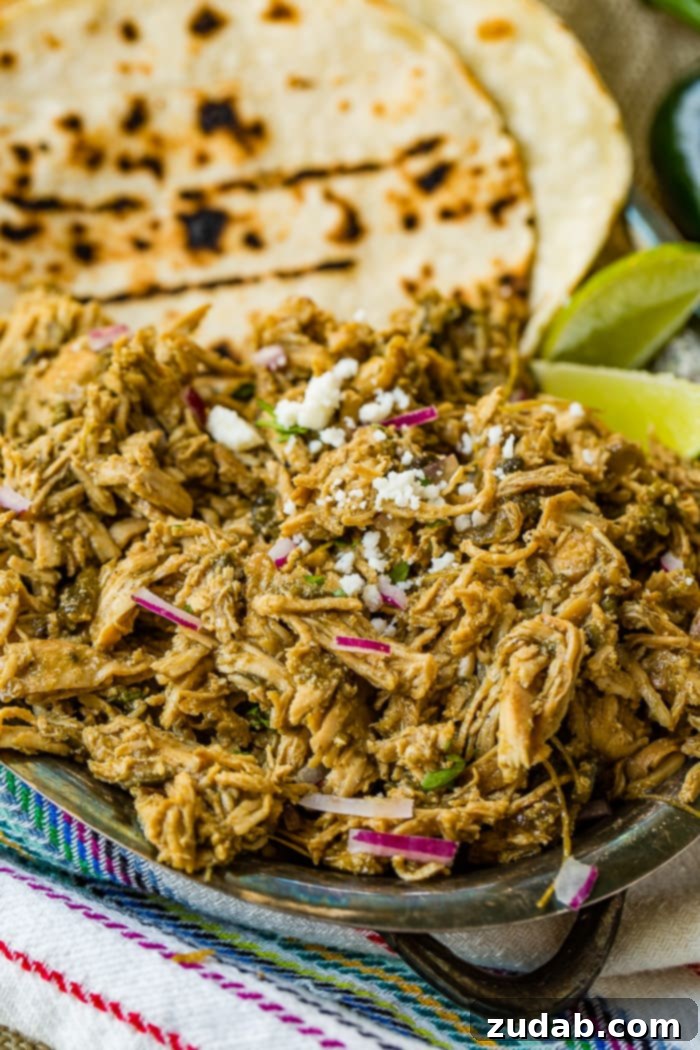 Creamy Instant Pot Poblano Chicken 4 Another perspective of the silver platter with shredded Mexican Poblano Instant Pot Chicken, complemented by lime wedges and tortillas, highlighting the dish's vibrant appeal.