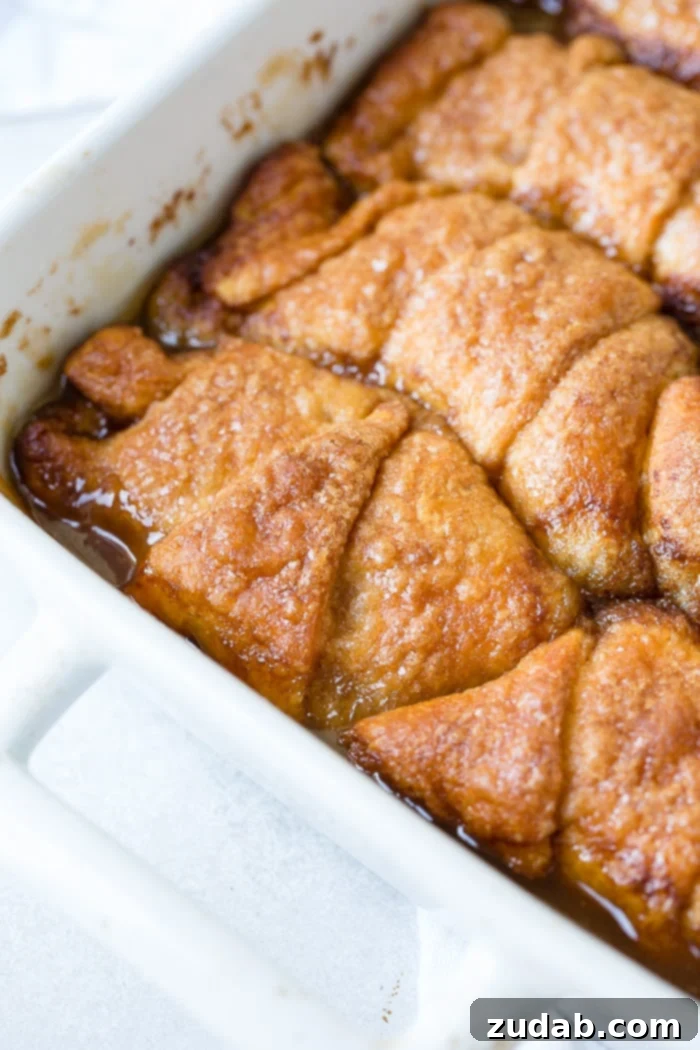 Sparkling Sprite Apple Dumplings 4 A white ceramic casserole dish filled with baked crescent roll apple dumplings, showing their golden-brown tops.