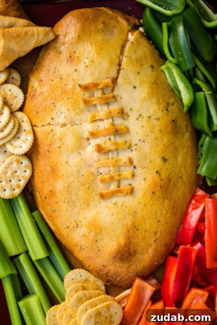 Touchdown Buffalo Chicken Dip 2 A cookie sheet with crackers, celery, peppers, and a football made out of crescent rolls and stuffed with buffalo chicken dip recipe