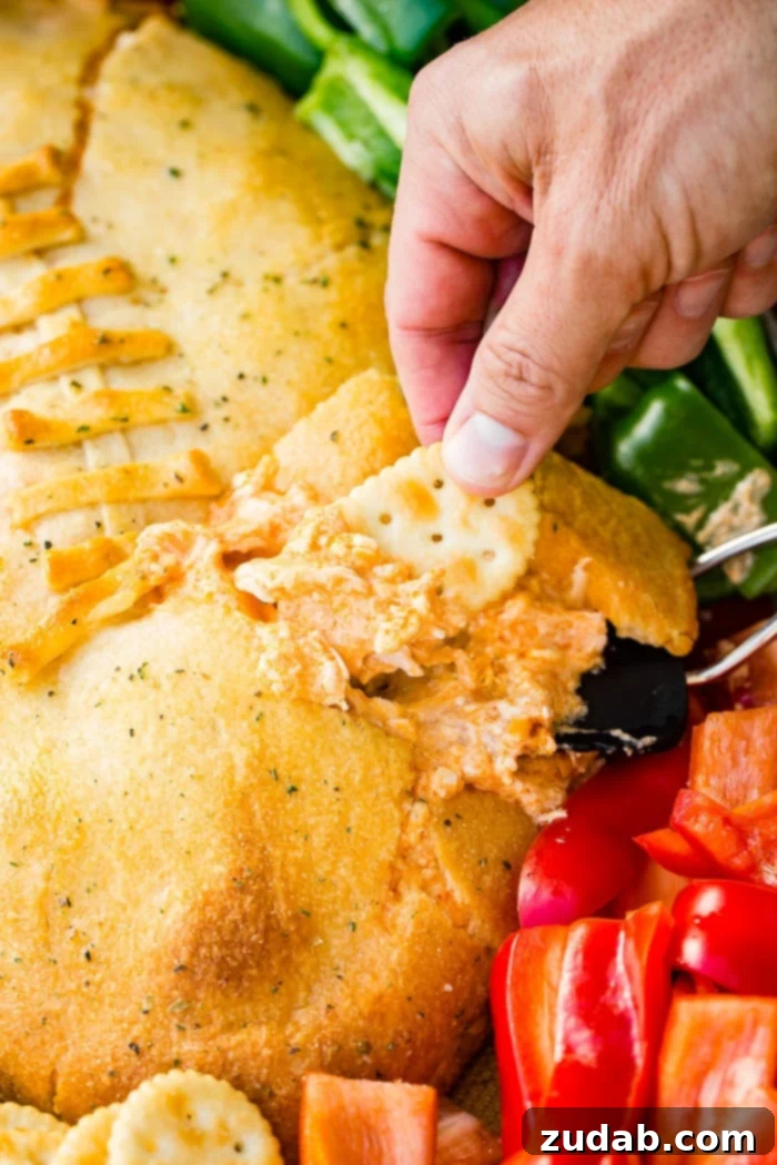 Touchdown Buffalo Chicken Dip 3 A cookie sheet with crackers, celery, peppers, and a football made out of crescent rolls and stuffed with buffalo chicken dip recipe