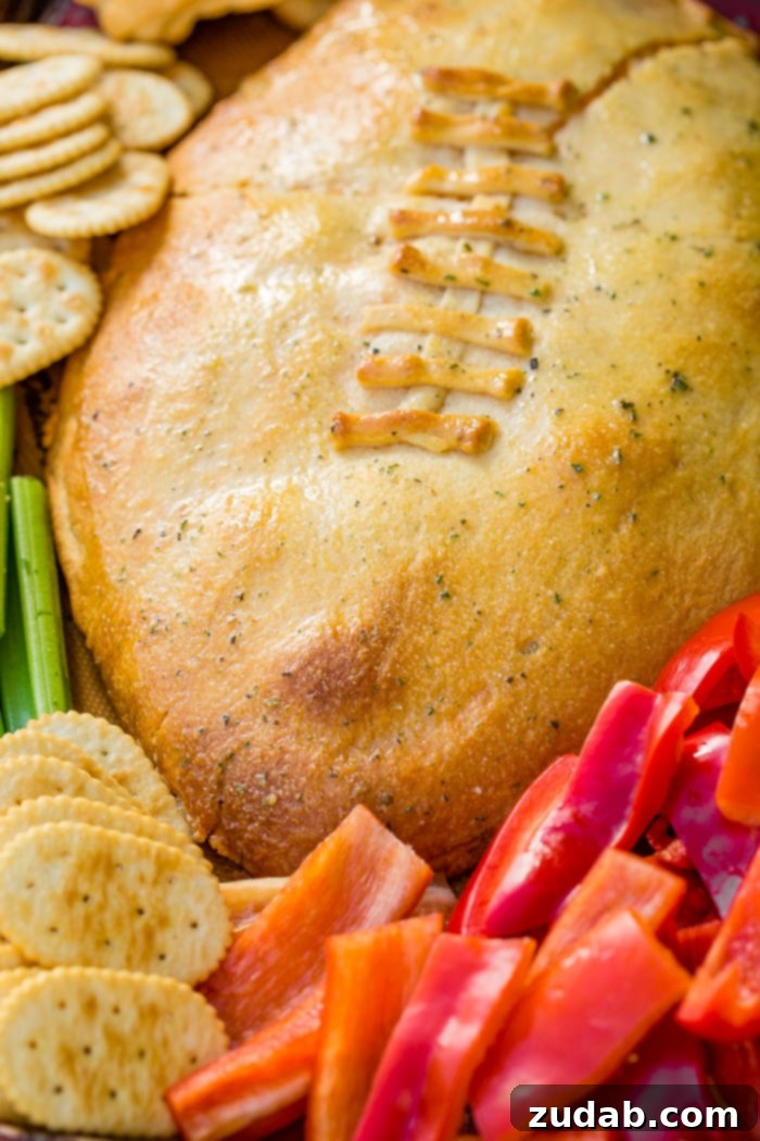 Touchdown Buffalo Chicken Dip 5 A cookie sheet with crackers, celery, peppers, and a football made out of crescent rolls and stuffed with buffalo chicken dip recipe