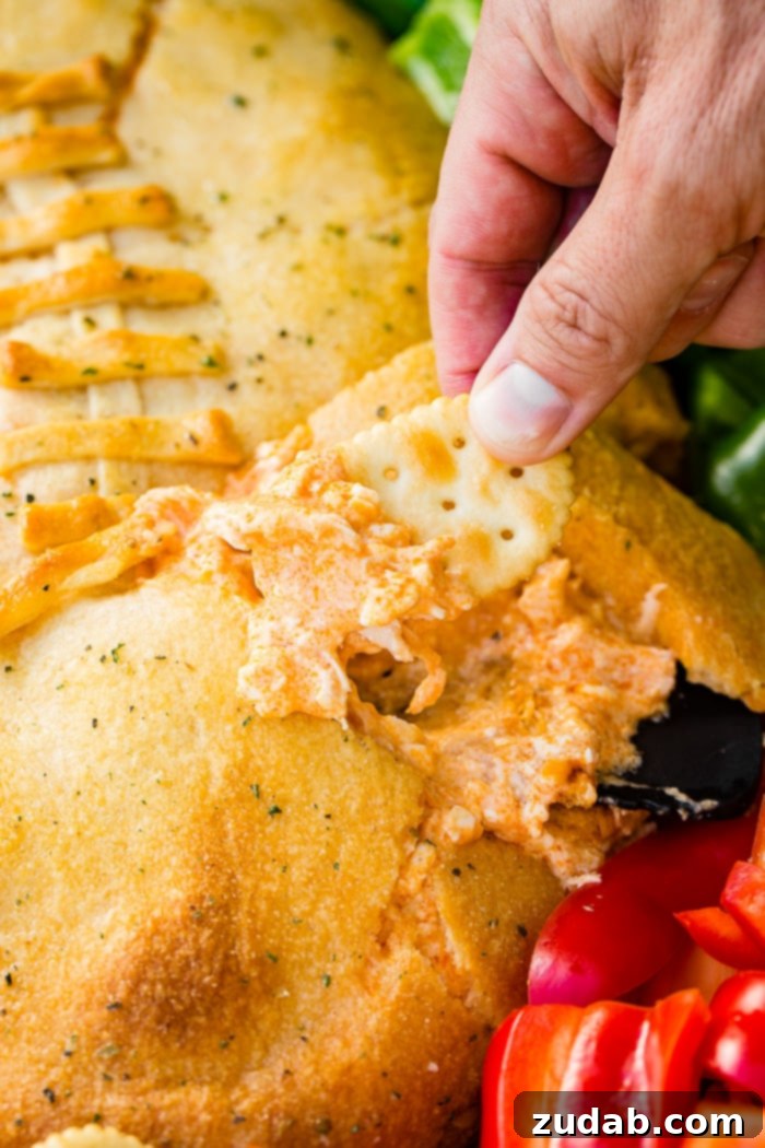 Touchdown Buffalo Chicken Dip 8 A cookie sheet with crackers, celery, peppers, and a football made out of crescent rolls and stuffed with buffalo chicken dip recipe