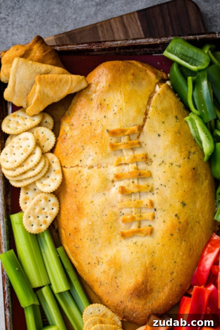 Touchdown Buffalo Chicken Dip 9 A cookie sheet with crackers, celery, peppers, and a football made out of crescent rolls and stuffed with buffalo chicken dip recipe
