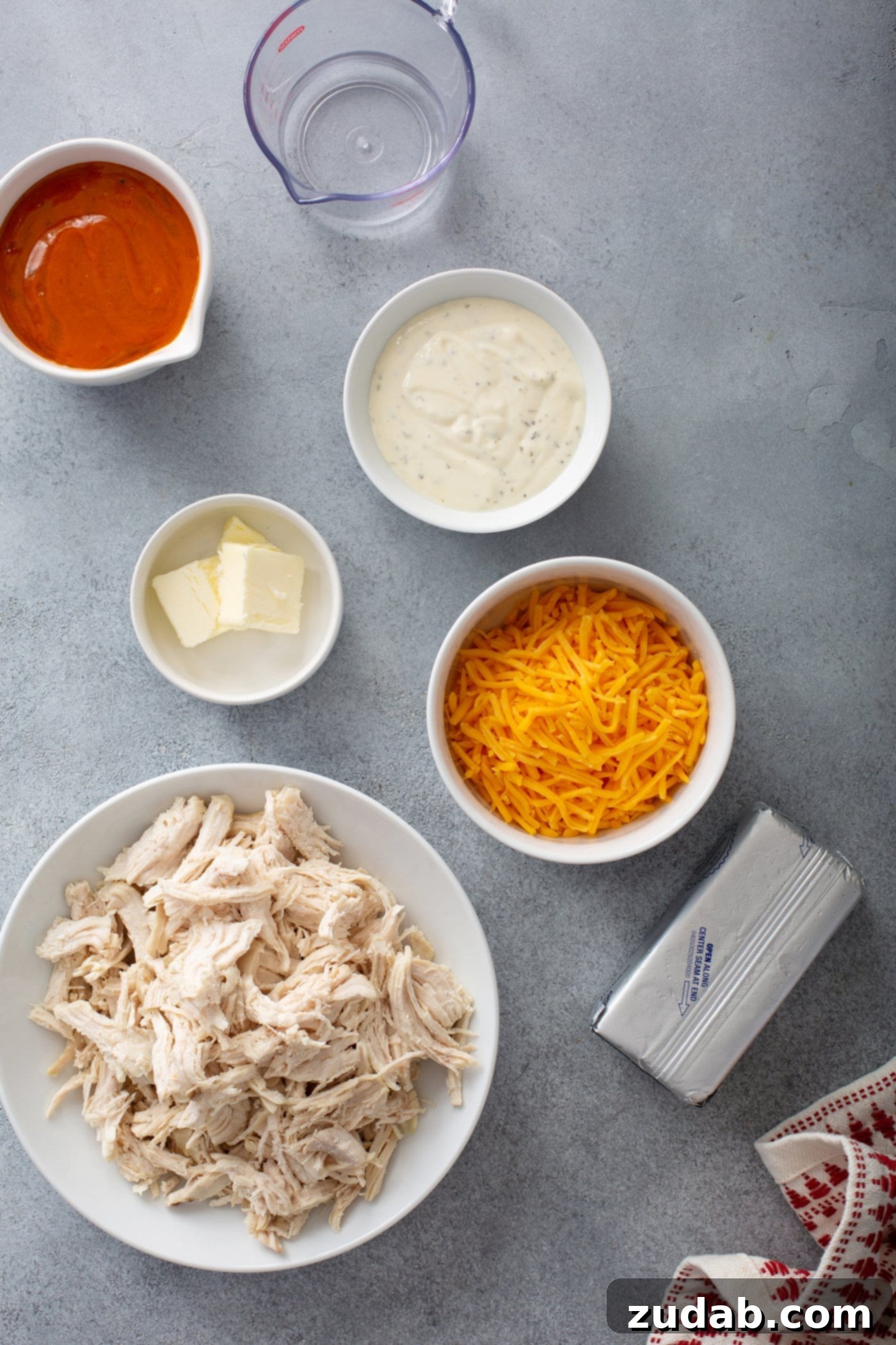 Instant Pot Buffalo Chicken Dip Small containers of shredded chicken, cheese, hot sauce, ranch dressing and butter.